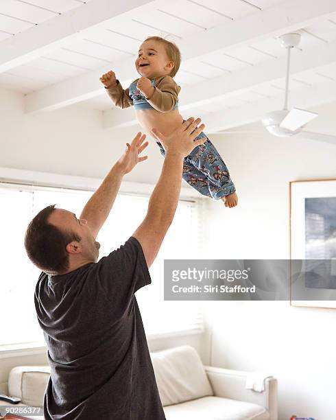 father tossing you boy up in the air - hurling stock pictures, royalty-free photos & images