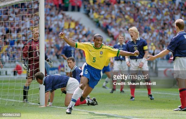 Cesar Sampaio of Brazil celebrates scoring the opening goal of the World Cup as Scotland captain Colin Hendry reacts during the group A game against...