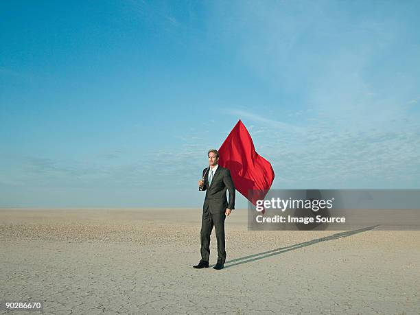 businessman holding a red flag in a desert - flag ストックフォトと画像