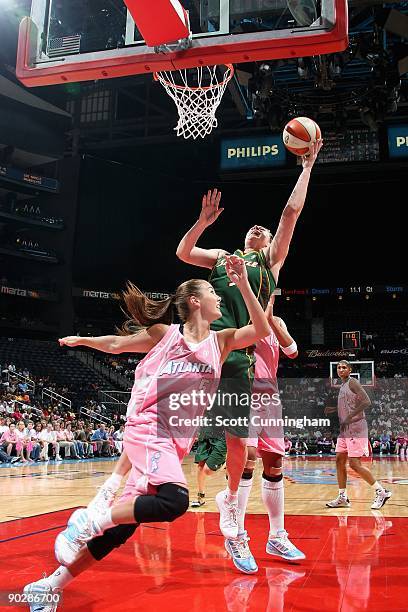 Suzy Batkovic-Brown of the Seattle Storm puts a shot up over Erika de Souza and Shalee Lehning of the Atlanta Dream during the WNBA game on August...