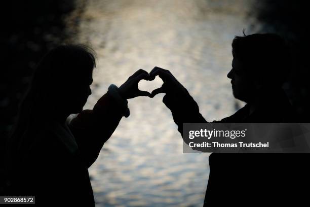 Berlin, Germany Posed scene: A young couple formed a heart with their hands on January 08, 2018 in Berlin, Germany.