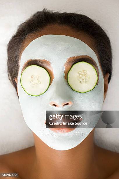 woman wearing face mask and cucumber - compassionate eye stockfoto's en -beelden