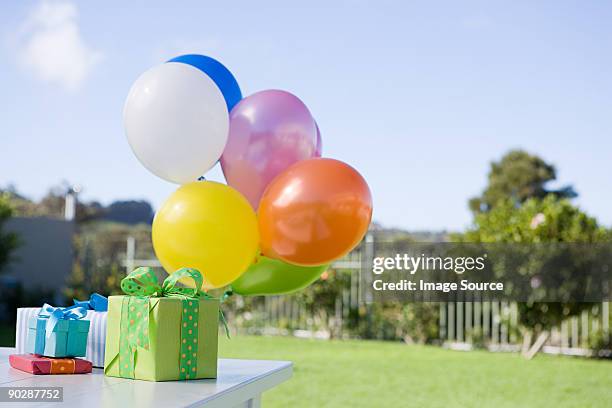 geburtstag mit luftballons und präsentiert auf einem tisch im garten - birthday present stock-fotos und bilder