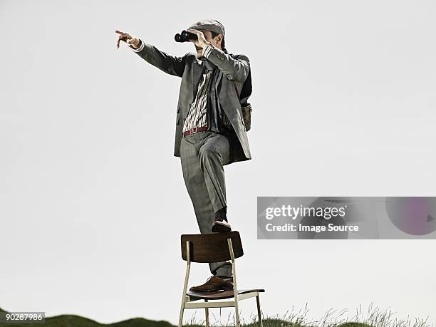 man in chair with binoculars - hat and suit stock pictures, royalty-free photos & images