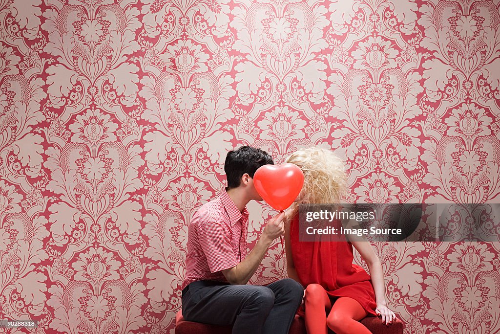 Couple derrière le ballon en forme de cœur