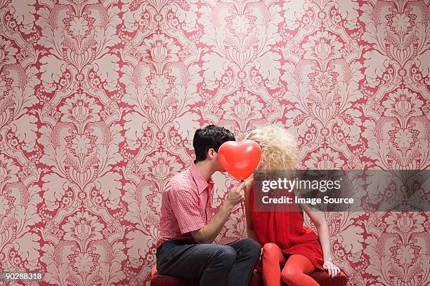 couple derrière le ballon en forme de cœur - fleur bleue photos et images de collection