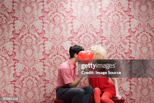 Couple behind heart shaped balloon Couple behind heart shaped balloon