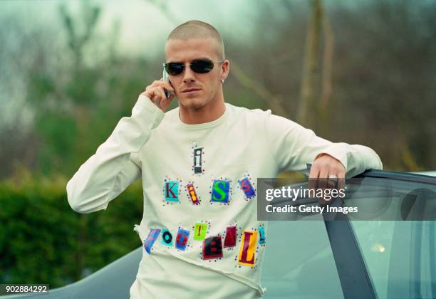 England player David Beckham on his mobile phone at the launch of the Adidas 'I kiss Football' campaign at adidas HQ in Stockport on March 15, 2001 .