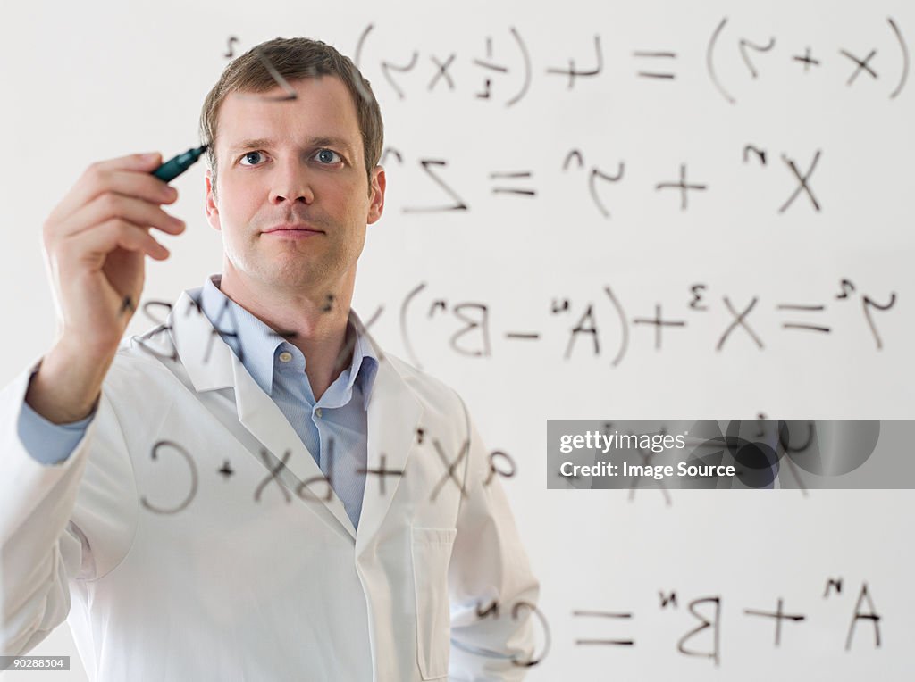 Male scientist working out a formula