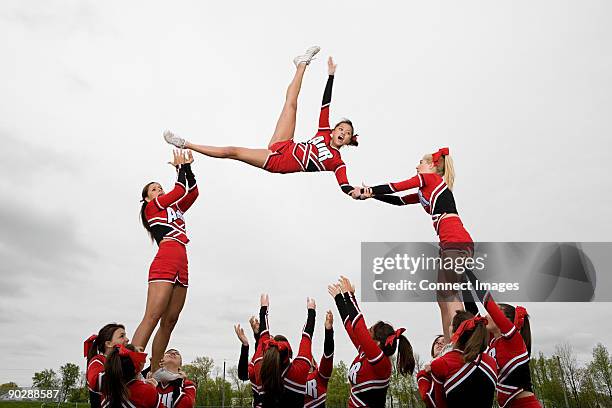 cheerleaders performing routine - cheerleader stockfoto's en -beelden