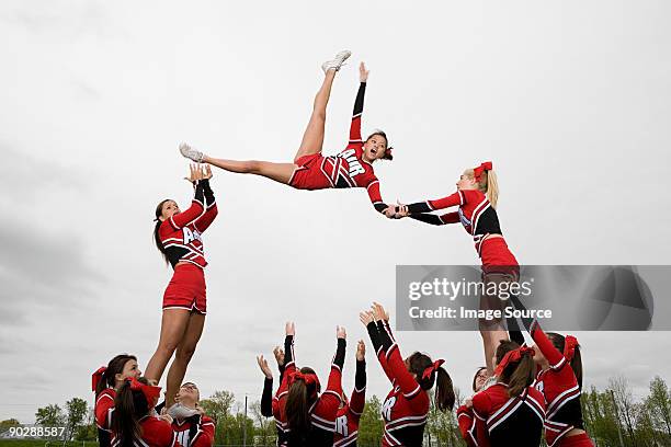 cheerleaders performing routine - cheerleader photos stock pictures, royalty-free photos & images