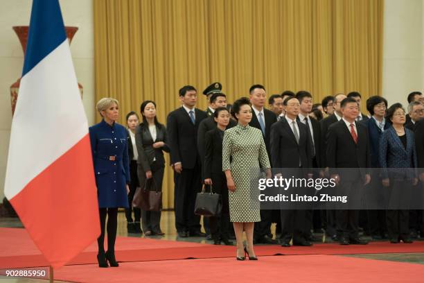 French President Emmanuel Macron's wife Brigitte Macron with First Lady Peng Liyuan loos on during a welcoming ceremony inside the Great Hall of the...