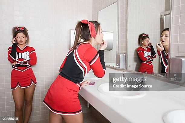 cheerleaders in restroom - teen cheerleader - fotografias e filmes do acervo