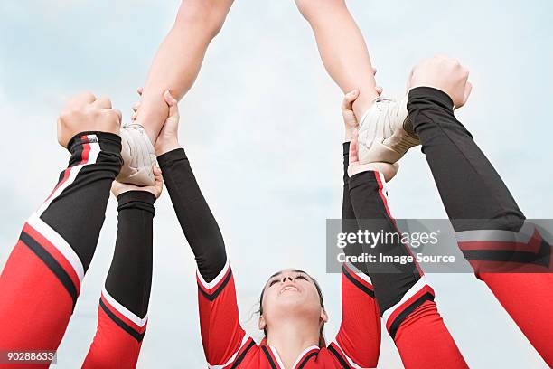 cheerleaders performing routine - cheerleader stock pictures, royalty-free photos & images