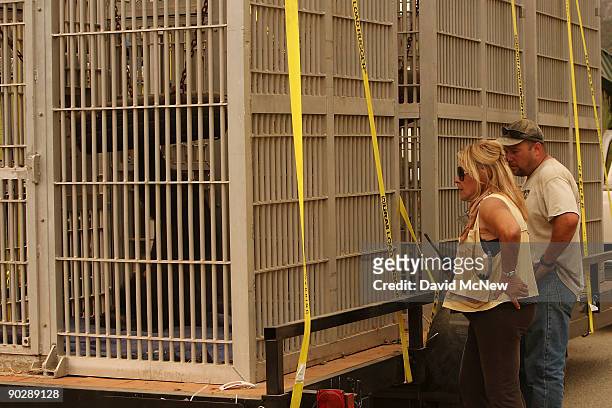 Wildlife Waystation founder Martine Colette checks on caged chimpanzees awaiting transport on a trailer as workers and volunteers evacuate animals...