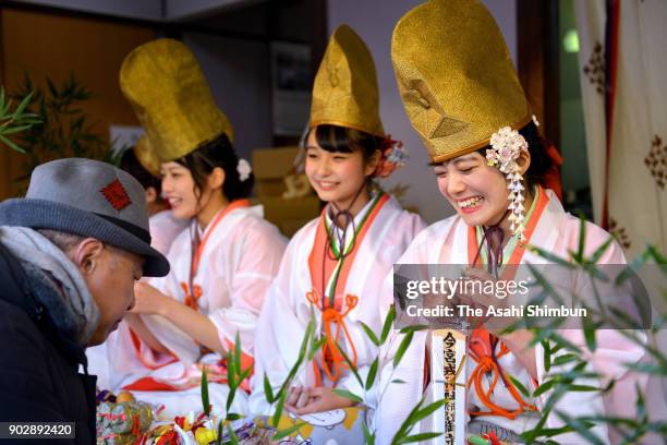 Shrine maidens called 'Fukumusune' or lucky girls attach ornaments to bamboo leaves 'Fukuzasa' or lucky bamboo, as Toka Ebisu festival begins at...