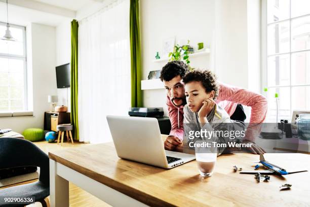 dad helping son use computer to do homework - dad homework stock pictures, royalty-free photos & images