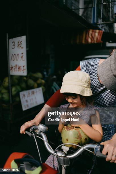 child sitting in bicycle child seat, drinking coconut water - 2 coconut drinks ストックフォトと画像