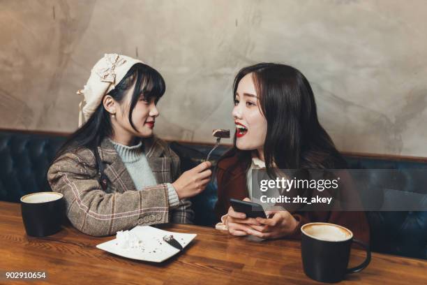 deux femmes appréciant les aliments au café - zhz photos et images de collection