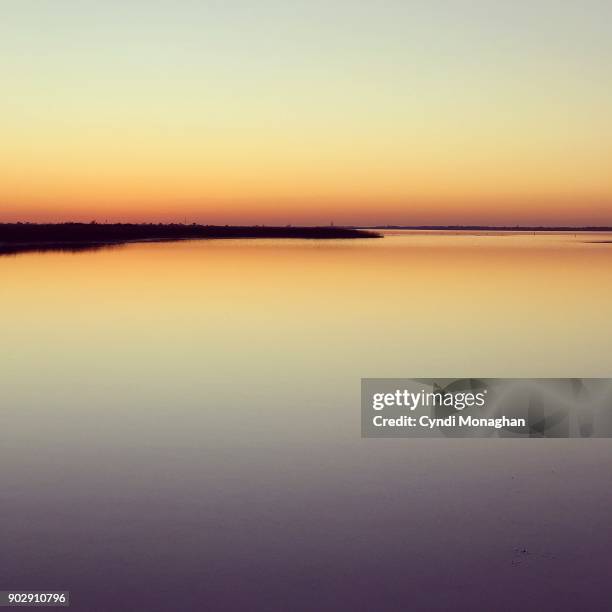 orange and golden light reflected across water - ombré imagens e fotografias de stock