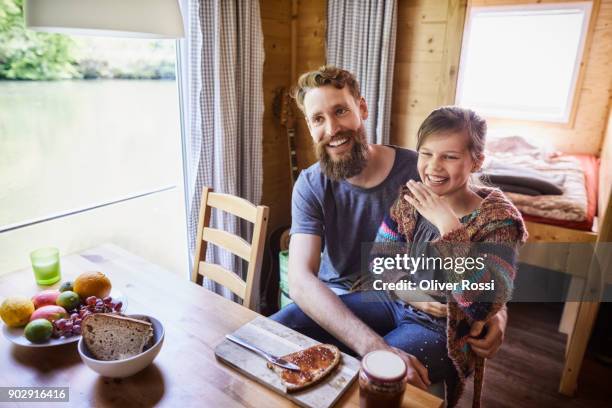 happy father and daughter having breakfast on a houseboat - girls laughing eating sandwich foto e immagini stock