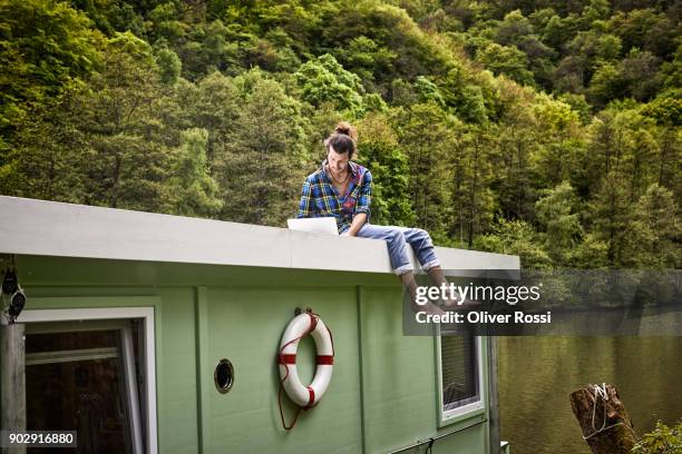 man using laptop on a houseboat - bare feet male tree stock pictures, royalty-free photos & images