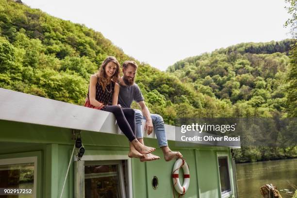 happy couple relaxing on a houseboat - hausboot stock-fotos und bilder