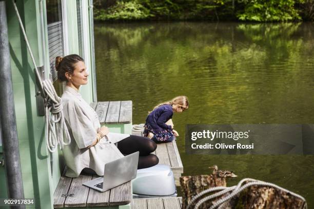 woman with daughter and laptop on a houseboat - houseboat stock pictures, royalty-free photos & images