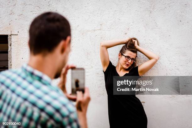 man taking snapshot of his smiling girlfriend - photographing bildbanksfoton och bilder