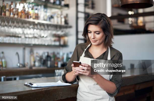 making sure that everyone is coming to work today - restaurant manager phone stock pictures, royalty-free photos & images