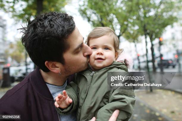 a 1 year old baby girl in the arms of her dad in the street - 2 year old blonde girl father ストックフォトと画像