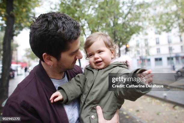 a 1 year old baby girl in the arms of her dad in the street - 2 year old blonde girl father ストックフォトと画像
