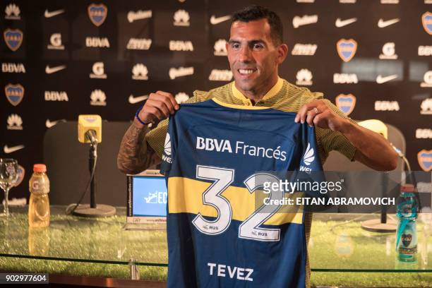 Boca Juniors' newly returned player Carlos Tevez poses with his new jersey during his official presentation at Los Cardales, Buenos Aires province,...