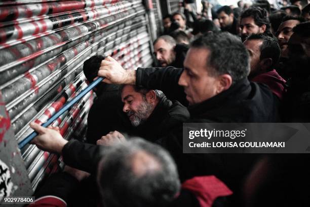 Communist-affiliated PAME workers unionists break into the Ministry of Labour in Athens on January 9 during a protest against a law submited to the...