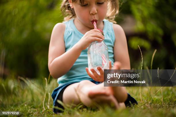 little girl child in lawn sipping water - törstig bildbanksfoton och bilder