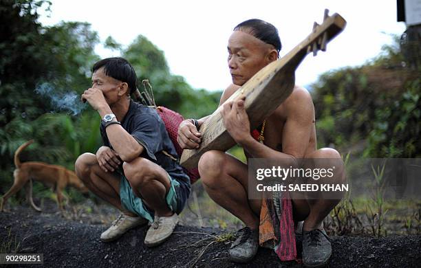 Malaysia-Penan-nomads-environment" by Sarah Stewart Members of the Penan tribe play traditional music outside their village Long Belok in Malaysia's...