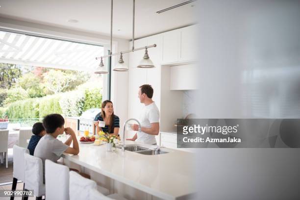 familia tomando el desayuno en la cocina - family at kitchen fotografías e imágenes de stock