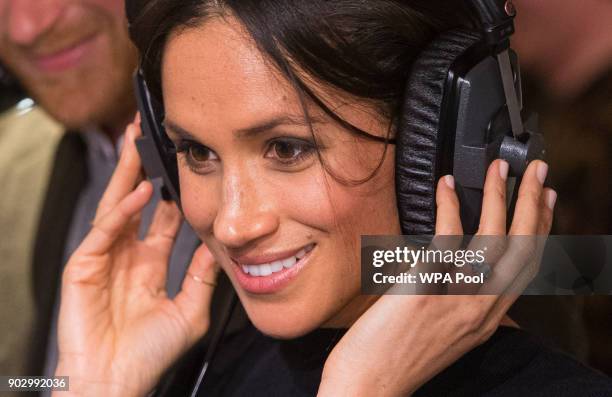 Meghan Markle listens to a broadcast through headphones at Reprezent 107.3FM in Pop Brixton on January 9, 2018 in London, England. The Reprezent...