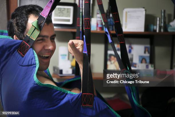 Jose Rodriguez Jr. Jokes as he swings from his sling at his home on Wednesday, Dec. 13, 2017 in Aurora, Ill. In August of 2013, Rodriquez Jr....