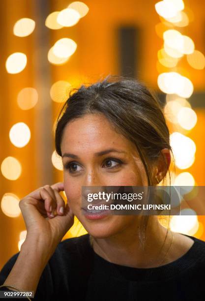 Britain's Prince Harry's fiancée, US actress Meghan Markle gestures during a visit to Reprezent 107.3FM community radio station in Brixton, south...