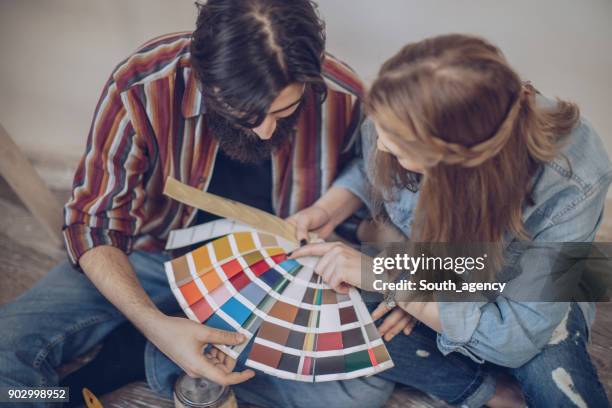 choosing colors - couple seated apartment hipster imagens e fotografias de stock