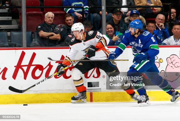 Christopher Tanev of the Vancouver Canucks checks Rickard Rakell of the Anaheim Ducks during their NHL game at Rogers Arena January 2, 2018 in...