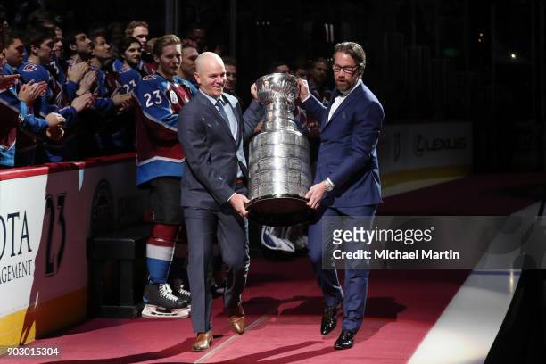 Retired Colorado Avalanche players Peter Forsberg and Alex Tanguay carry the Stanley Cup as a suprise during a ceremony to retire Hejduk's number,...
