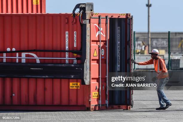 Worker is pictured at a container yard of the main port of "La Guaira" in Caracas on January 9 , 2018. / AFP PHOTO / JUAN BARRETO