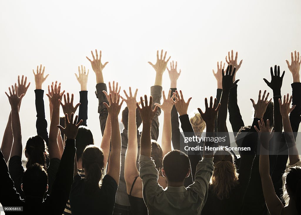 Group of people with their hands raised