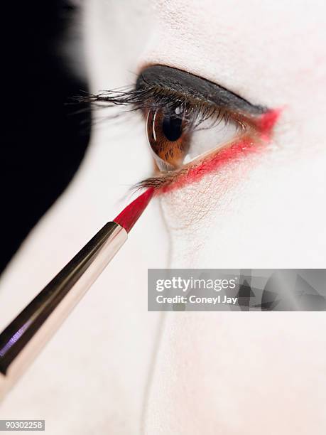 close up of geisha putting on red eyeliner - coneyl - fotografias e filmes do acervo