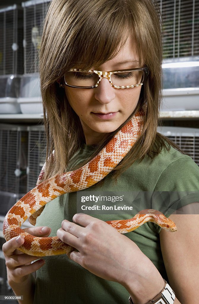 Girl holding grass snake around neck