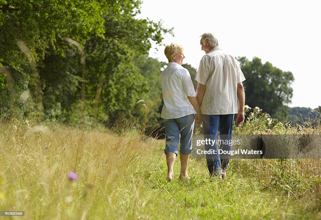 Elderly couple walking hand in hand.