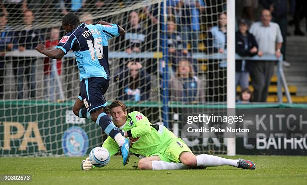 Chris Dunn of Northampton Town saves at the feet of Jon-Paul Pittman of Wycombe Wanderers during the Johnstone's Paint Trophy First Round Match...
