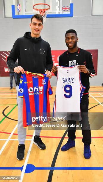 Dario Saric of the Philadelphia 76ers and Jeffrey Schlupp of Crystal Palace football team poses for a photo with a Crystal Palace football player...